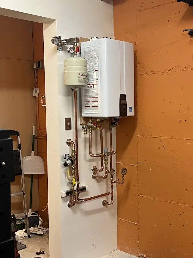 Plumbing technician inspecting water heater connections in Maumee